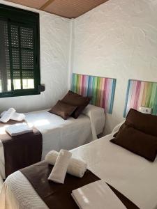 a room with two beds and a window at CASA CHOCOLATE in Malcocinado