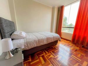 ein Schlafzimmer mit einem Bett und einem großen Fenster in der Unterkunft Acogedor y lindo Departamento en estreno in Lima