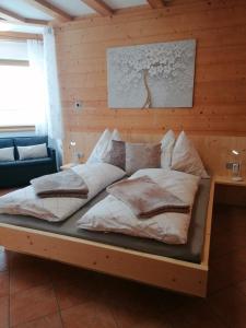 a bed in a room with a wooden wall at Ferienwohnung Mireille in Oberperfuss