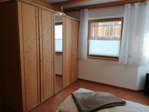 a bedroom with wooden cabinets and a window at Ferienwohnung Mireille in Oberperfuss