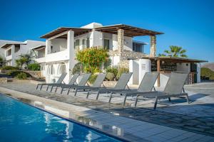 a group of lounge chairs next to a house at Irenes View Apartments in Agia Irini Paros