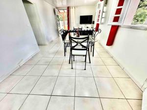 une salle à manger avec une table et des chaises sur un sol carrelé dans l'établissement Villa Dom's Evasion, à Sainte-Marie