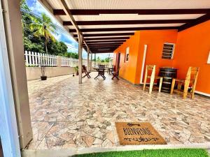 un patio avec une table et des chaises et un bâtiment orange dans l'établissement Villa Dom's Evasion, à Sainte-Marie