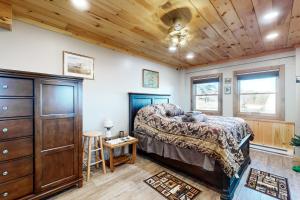 a bedroom with a bed and a wooden ceiling at The Gambrel House in Pulteney