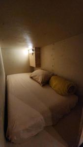 a bedroom with a bed with a light on the wall at Komo Pod Hotel in London