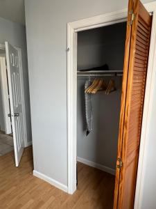 un armario con una puerta abierta con perchas en Cozy apartment nexttomain st, en Passaic