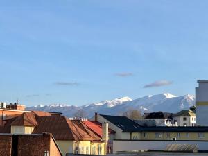 a city with snow covered mountains in the background at Apartmán v centre Žiliny s parkovaním in Žilina