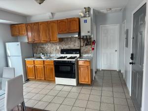 a kitchen with wooden cabinets and a stove top oven at Cozy apartment nexttomain st in Passaic