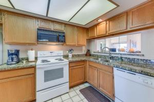 a kitchen with white appliances and wooden cabinets at Mesa Condo Rental with Community Pool Access! in Mesa