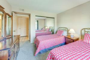 a bedroom with three beds with red and white sheets at Mesa Condo Rental with Community Pool Access! in Mesa +23 photos