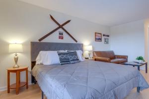 a bedroom with a large bed and a chair at Bellaire Vacation Rental - Ski Shuttle Access! in Bellaire