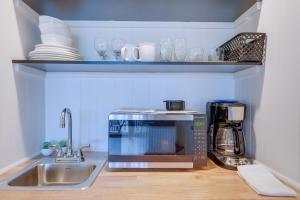 a kitchen counter with a microwave and a sink at Bellaire Vacation Rental - Ski Shuttle Access! in Bellaire