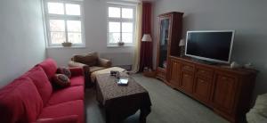 uma sala de estar com um sofá vermelho e uma televisão em Apartament u podnóża Gór Stołowych em Radków