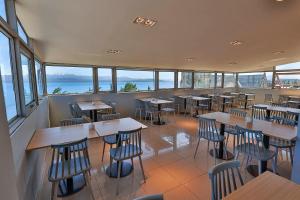 ein Restaurant mit Tischen und Stühlen und dem Meer in der Unterkunft Hotel Plaza Bariloche in San Carlos de Bariloche