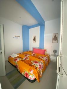 a bedroom with a bed with an orange blanket at Suite Big Lanche in Praia Baixo