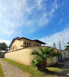 ein Gebäude mit einer Palme davor in der Unterkunft Casa da Edna in Guarujá