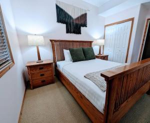 ein Schlafzimmer mit einem Holzbett mit grünen Kissen in der Unterkunft Chicamon Springs Lodge by FantasticStay in Kimberley