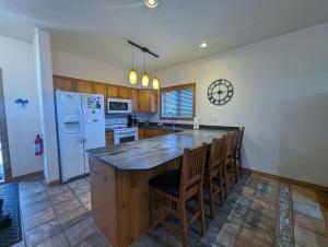 a kitchen with a large kitchen island with chairs at Chicamon Springs Lodge by FantasticStay in Kimberley