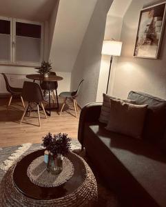 een woonkamer met een bank en een tafel bij Gemütliche Altstadtwohnung mit Balkon Smart-TV in Erfurt