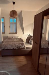 een slaapkamer met een bed, een raam en een spiegel bij Gemütliche Altstadtwohnung mit Balkon Smart-TV in Erfurt