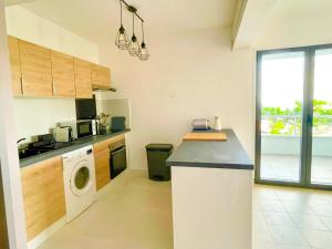 a kitchen with a washing machine and a washer at VILLA MAGIC - Ocean Views with Pool, Starlink WiFi, Cistern & Generator in Oyster Pond