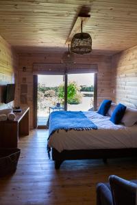 1 dormitorio con 1 cama grande en una habitación de madera en Cabañas Pichilemu Casa Verde, en Pichilemu