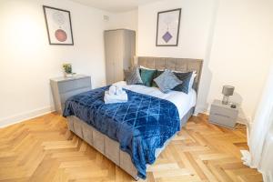 a bedroom with a bed with a blue comforter at One-bed flat Angel, Islington in London