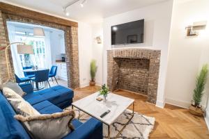 a living room with a blue couch and a fireplace at One-bed flat Angel, Islington in London
