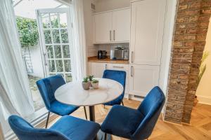 ein Esszimmer mit einem Tisch und blauen Stühlen in der Unterkunft One-bed flat Angel, Islington in London
