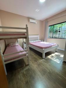 a bedroom with two bunk beds and a window at Fantástica Casa Praia Próxima ao Beto Carreiro in Penha +25 photos