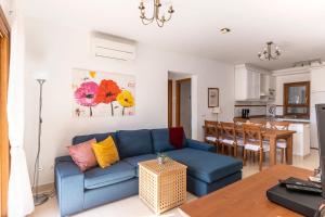 Una sala de estar con un sofá azul y una mesa. en Marina d'Or III - Villa 10, en Santanyí