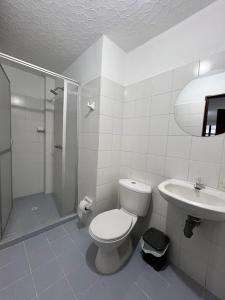 uma casa de banho com um WC, um chuveiro e um lavatório. em Hotel San Cayetano em Ocaña