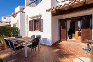 Un patio con una mesa y sillas de madera. en Marina d'Or III - Villa 10, en Santanyí