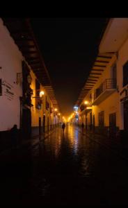 an empty street at night with a person walking down the street at TintayaHotel in Chachapoyas