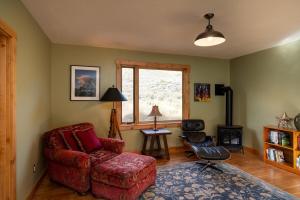 un soggiorno con sedia rossa e finestra di Triumph Ranch Farm House ad Hailey