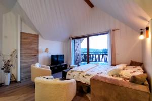 a bedroom with a bed and a large window at Magnifique appartement au pied des pistes - Le trelod in La Féclaz