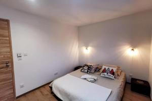 a bedroom with a bed with two pillows on it at Magnifique appartement au pied des pistes - Le trelod in La Féclaz