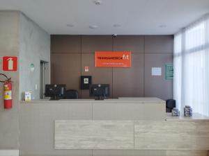 un vestíbulo del aeropuerto con un cartel naranja en la pared en Transamerica Fit Lafaiete, en Conselheiro Lafaiete