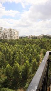een balkon met uitzicht op een bos met bomen bij Times Square CoLive in Bangalore
