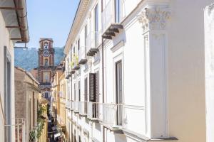 una calle de la ciudad con edificios blancos y una torre del reloj en Charming bedroom in Sorrento with balcony, en Sorrento