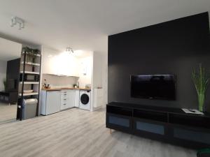 uma sala de estar com uma grande televisão de ecrã plano na parede em Wera em Klodzko