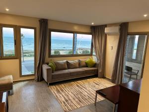 Oceana Mazagan Suites Hotel في الجديدة: غرفة معيشة مع أريكة وإطلالة على المحيط