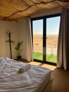Un dormitorio con una cama y una ventana grande en Royal desert camp, en Al Raka 48 fotos más
