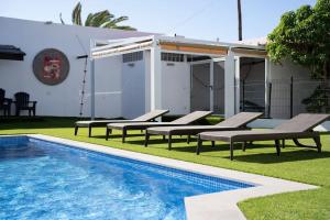 uma piscina com espreguiçadeiras e uma casa em Villa Mirador de los Abrigos em La Mareta