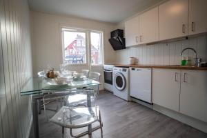 a kitchen with a table and a sink and a dishwasher at City Center Getaway 9 by Berti in Stavanger