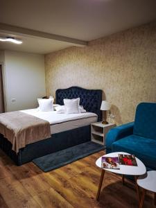 1 dormitorio con 1 cama y 1 sofá azul en Queen Doftana, en Teşila