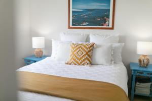 a bedroom with a bed with two blue tables at Lookout 100m to the Ocean and Pet-Friendly in Ocean Grove