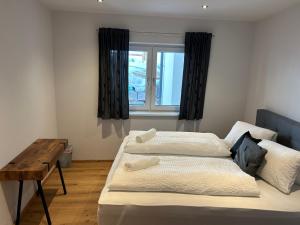 a bedroom with two beds and a table and a window at Apart 14 in Sankt Anton am Arlberg