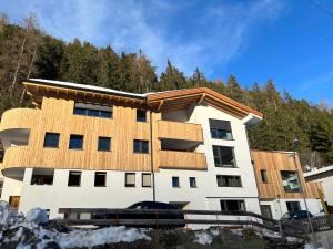 a white building with a wooden roof at Apart 14 in Sankt Anton am Arlberg