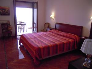 ヴィエステにあるResidence Hotel Torresilvanaのベッドルーム1室(赤いストライプの毛布付きのベッド1台付)